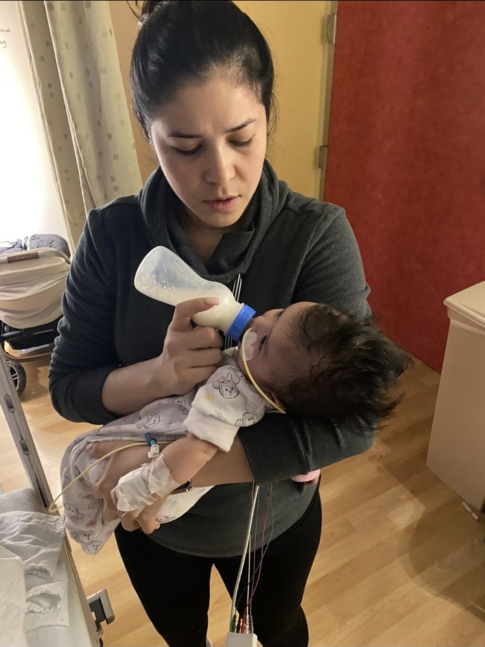 Nancy holding and feeding her daughter during a hospital stay